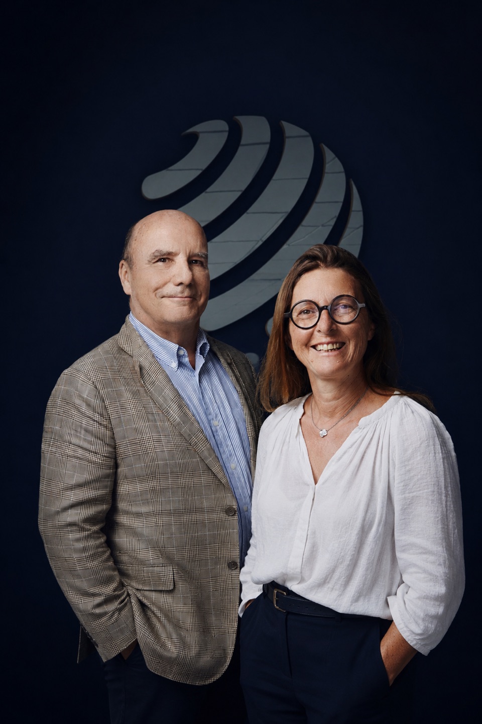 Pouey International executives against a navy brand background
